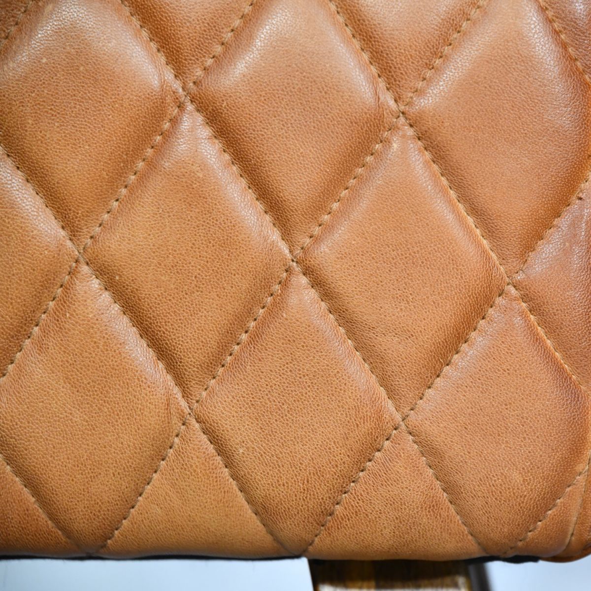 Close up of diamond stitching on tan leather foot stool