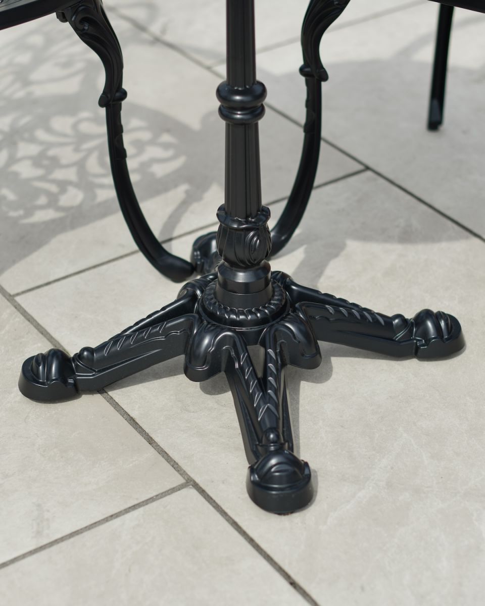 Close up of ornate table leg detail on two seater patio table and chairs set