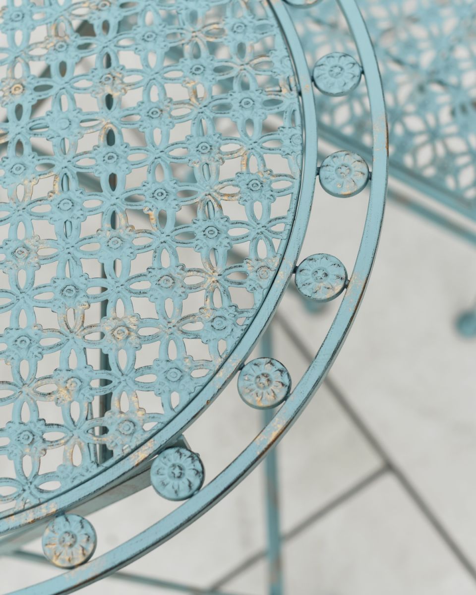 Close up of ornate detail on teal and green two seater outdoor furniture set