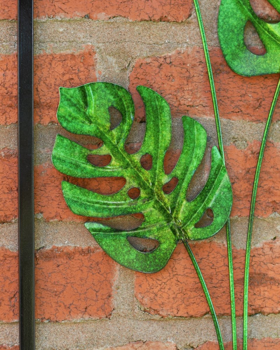 Close up of intricate steel cut out leaf detail on garden wall art