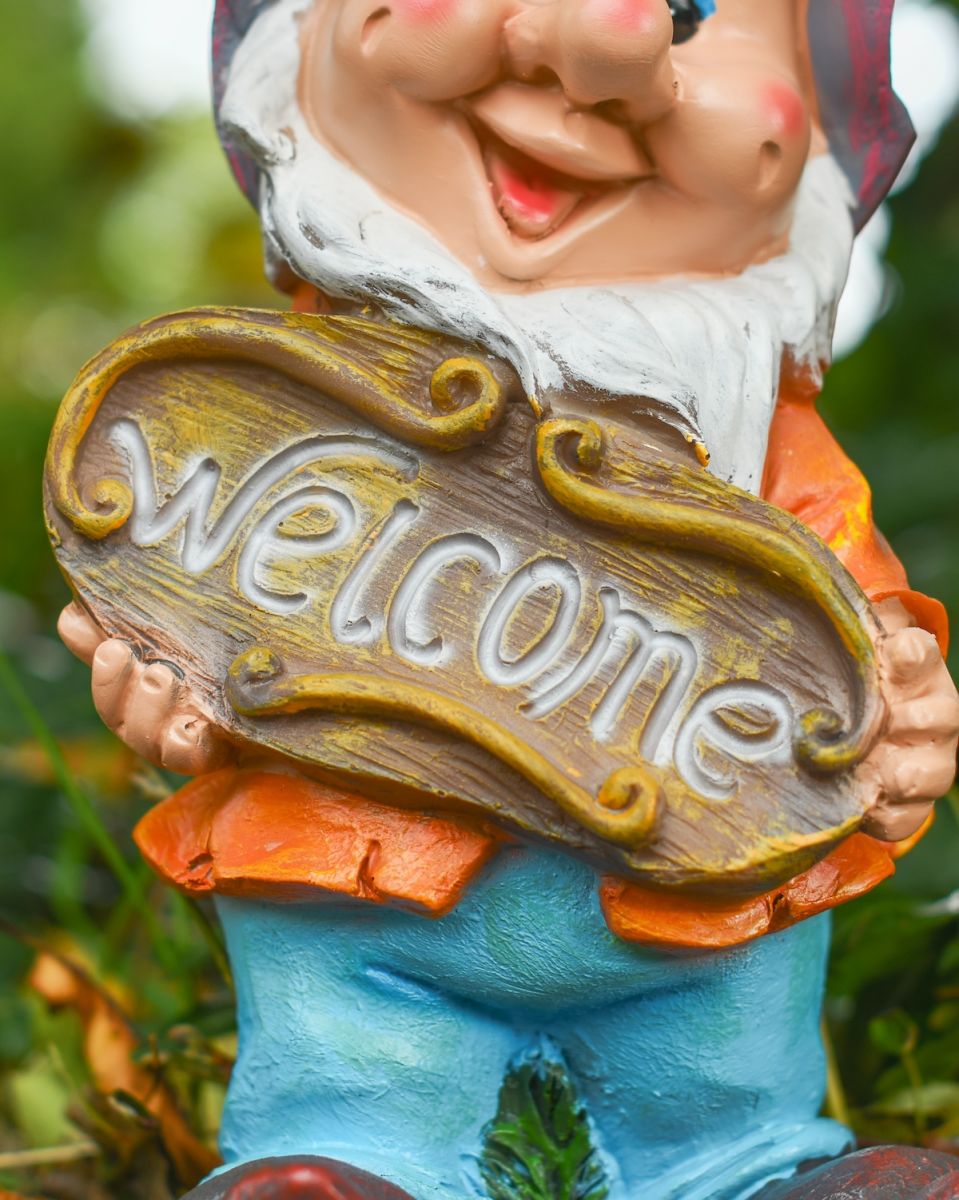 Close up of welcome sign on colourful garden gnome sculpture
