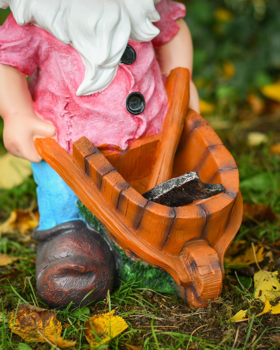 Close up of wheelbarrow detail on colourful garden gnome