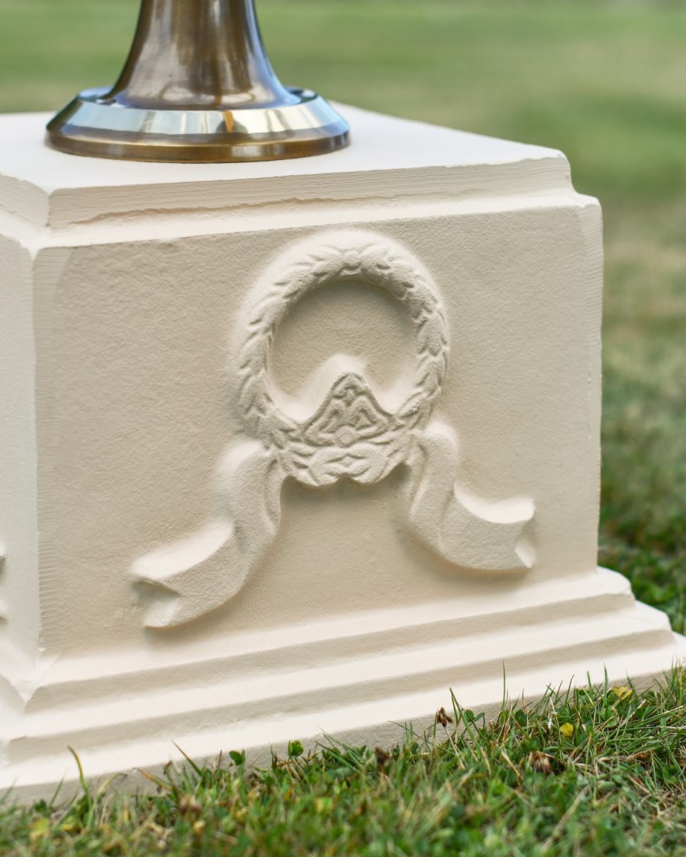 Close up of wreath and ribbon detail on garden sundial column