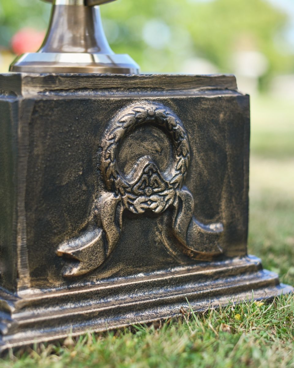 Close up of wreath and ribbon detail on brushed bronze garden column