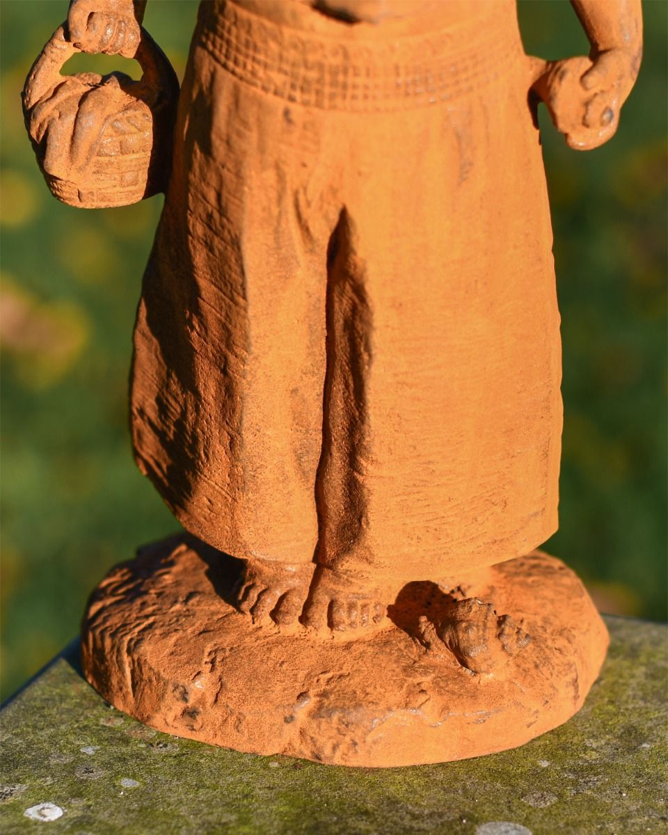 Close up of Rustic Cast Iron Girl With Basket  Close up of Rustic Cast Iron Girl With Basket