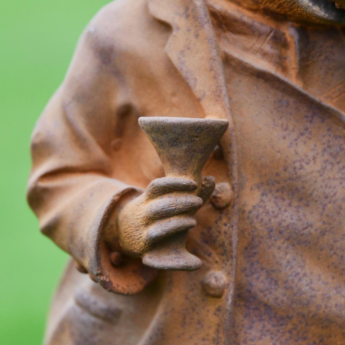 Close up of Hand and Glass on Cast Iron Sculpture  Close up of Hand and Glass on Cast Iron Sculpture