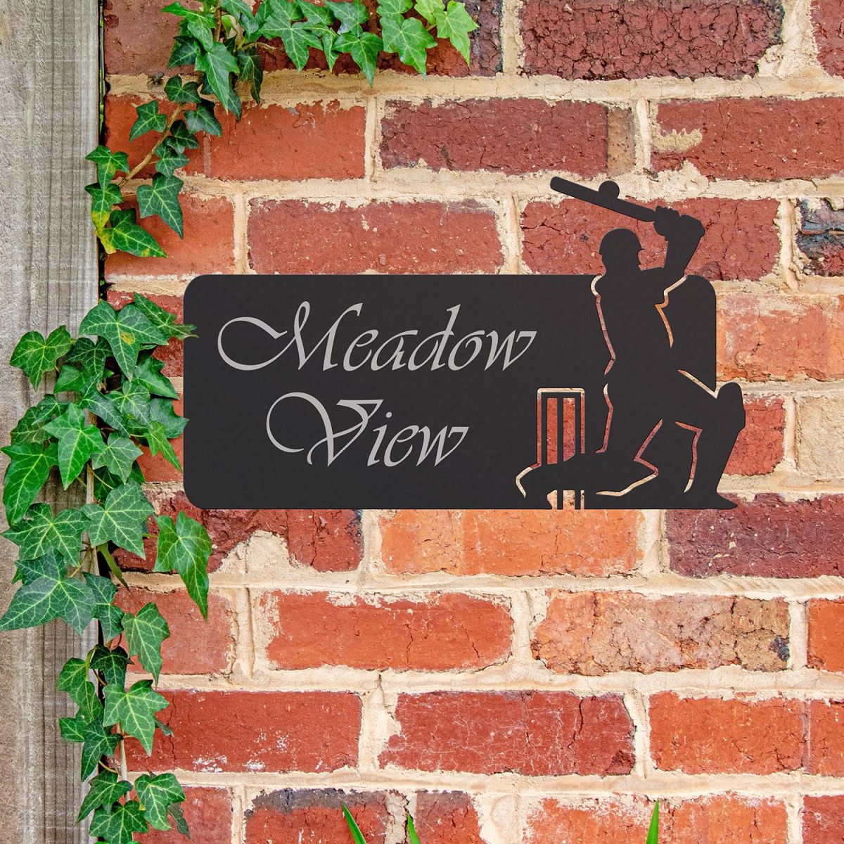 Cricket Player Iron House Name Sign in Use on a Brick Wall