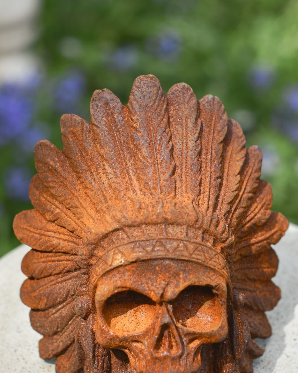 headdress detail on rusted cast iron garden skull ornament