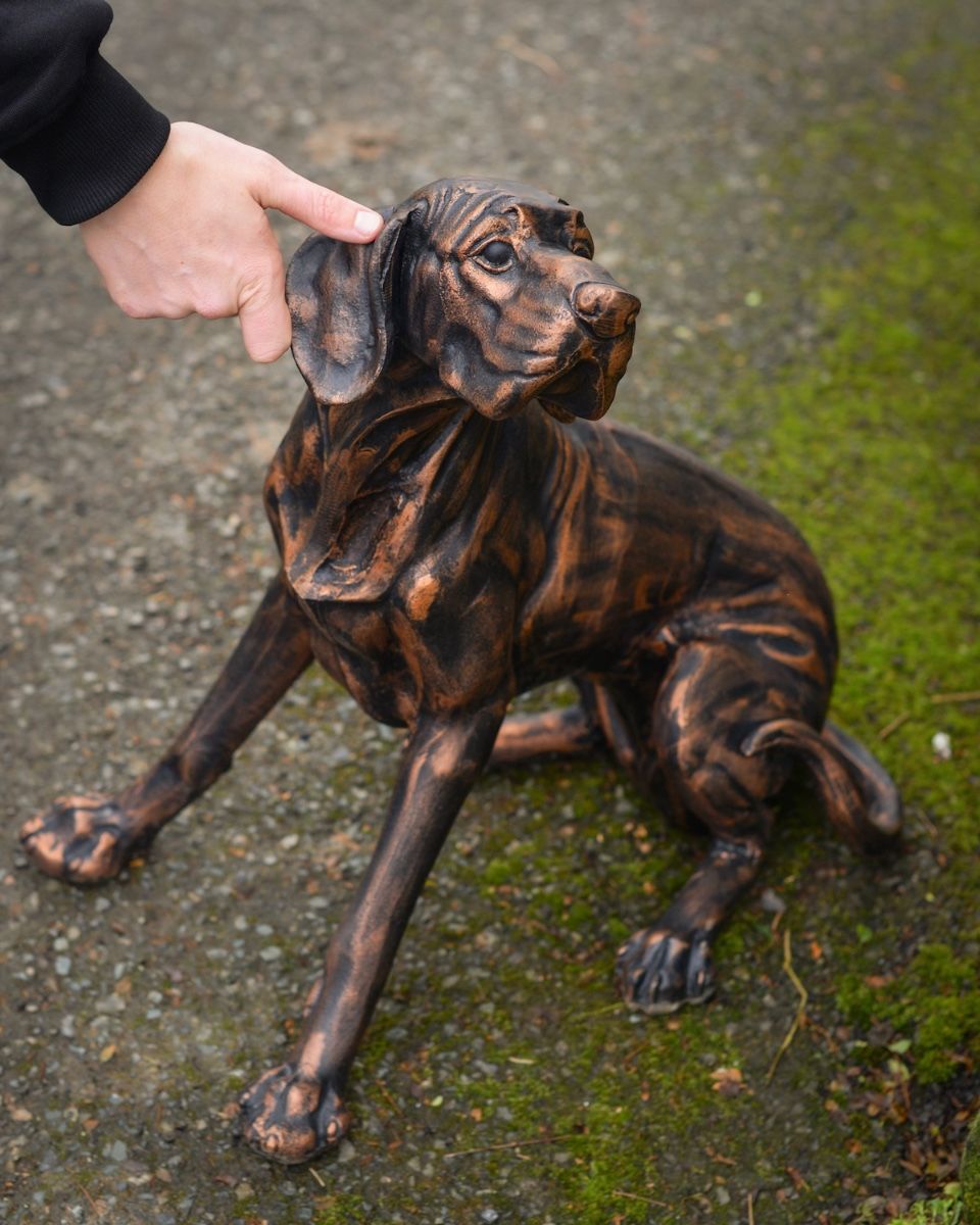 Digital Illustration of a Copper Version of "Duke" the Sitting Dog Sculpture in Cast Aluminium with Hand in Shot for Scale