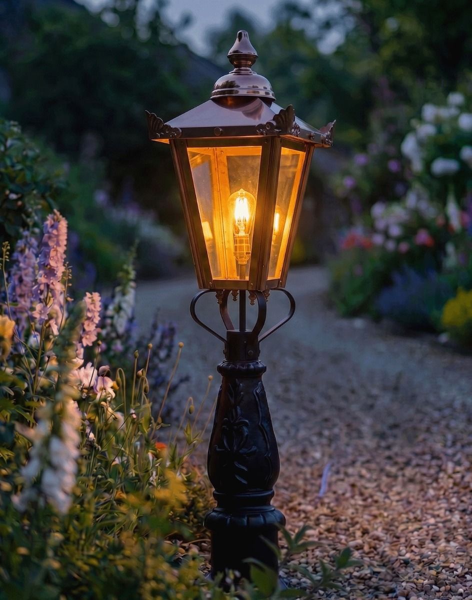 Digital Illustration of the 105cm "Crown Riversham" Copper Victorian Patio Lamp Post Placed on a Flowery Gravel Driveway and Lit up at Night