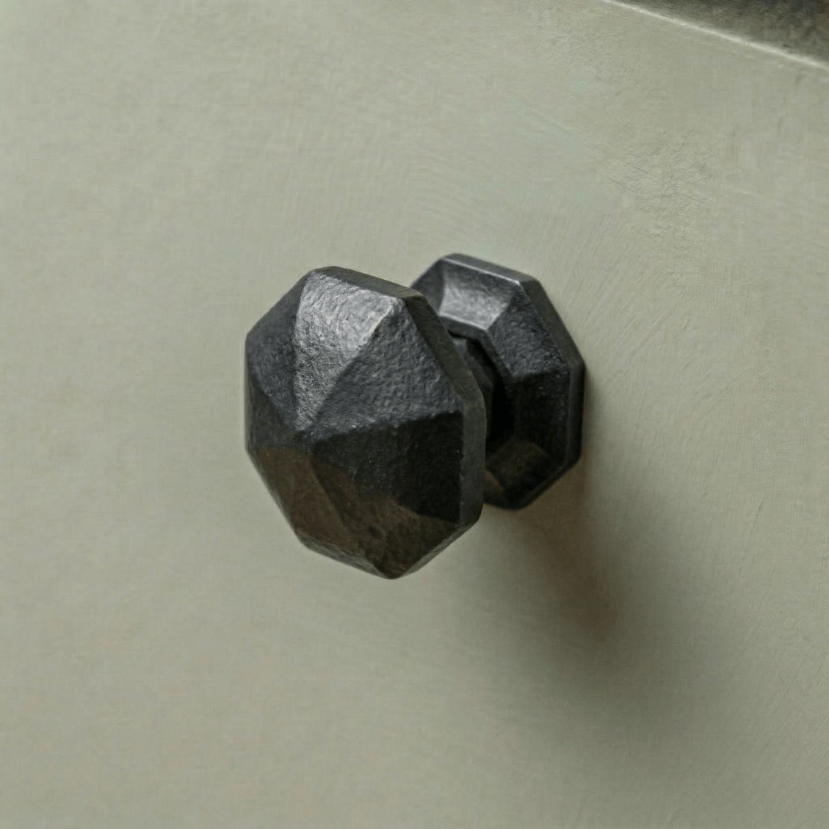 Digital Illustration of the 32mm Steel Beeswax Octagonal Cabinet Knob on a Sage Green Cupboard Door