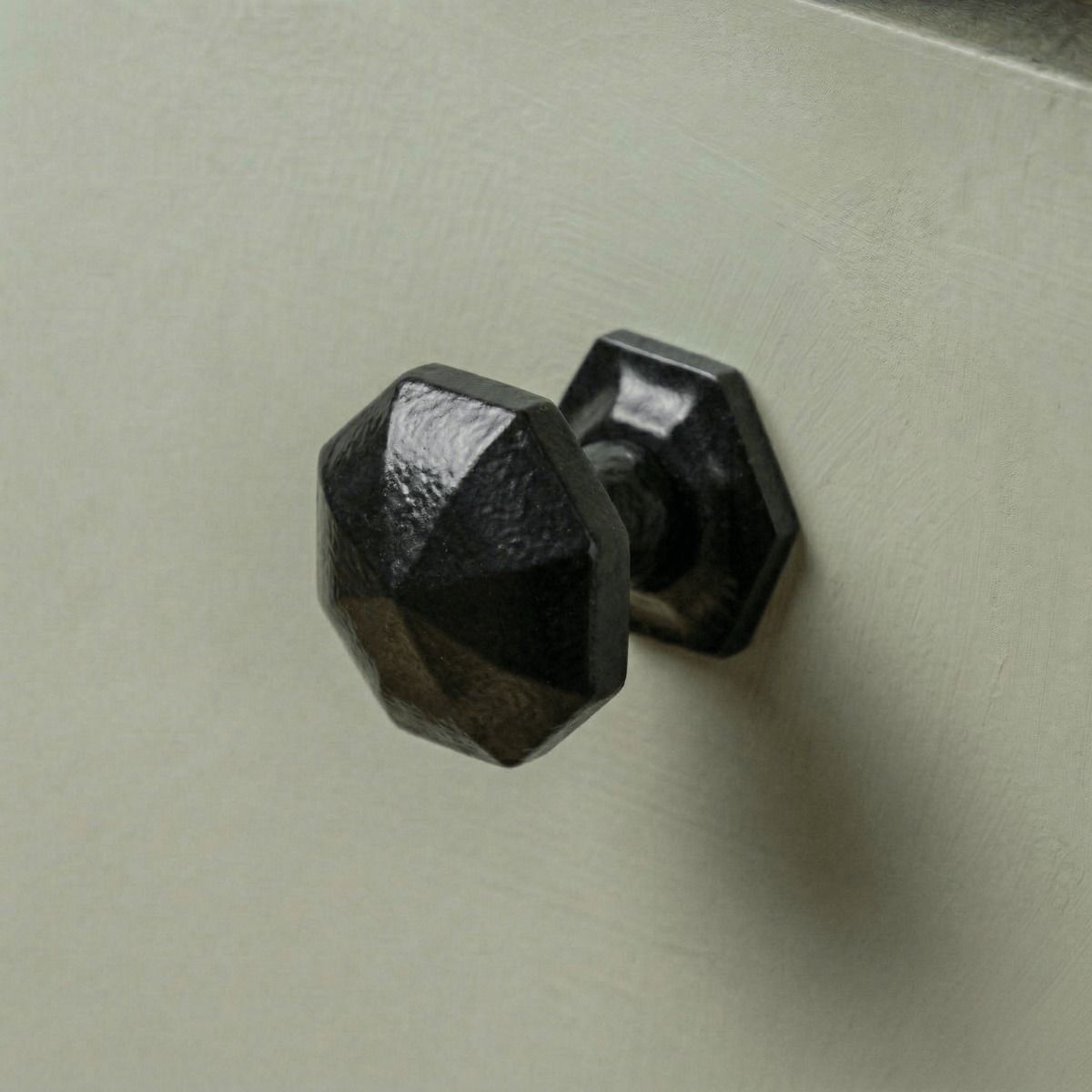 Digital Illustration of the 32mm Steel Powder Coated Octagonal Cabinet Knob Mounted on a Sage Green Cupboard Door