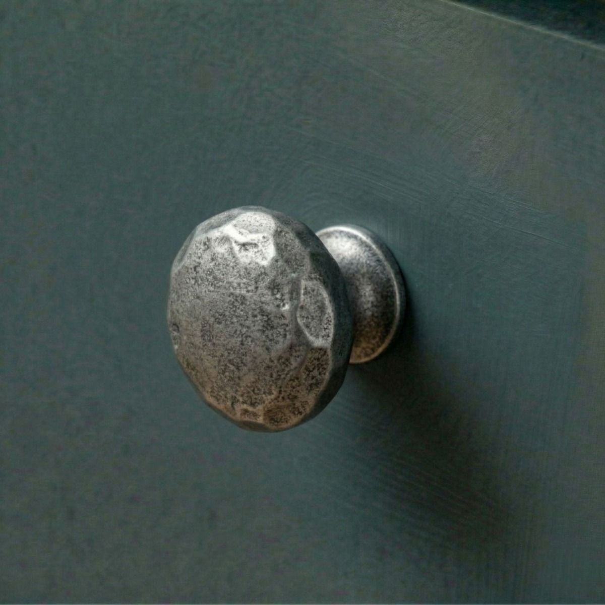 Digital Illustration of the 33mm Hammered Cast Iron Cabinet Knob Mounted on a Dark Blue Cupboard Door