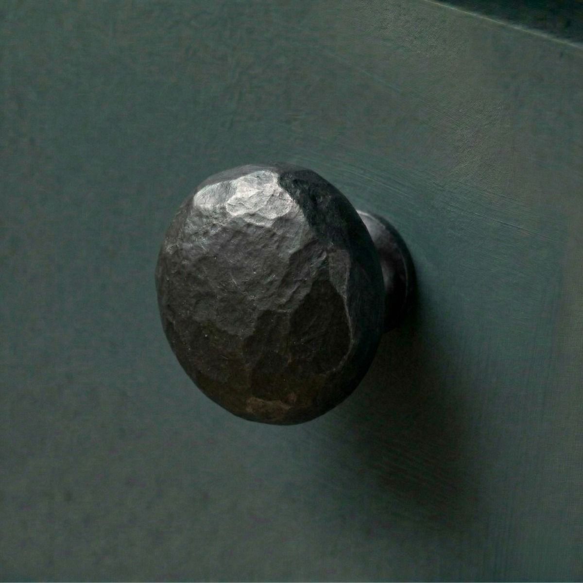 Digital Illustration of the 38mm Black Hammered Steel Cabinet Knob Mounted on a Blue Cupboard Door