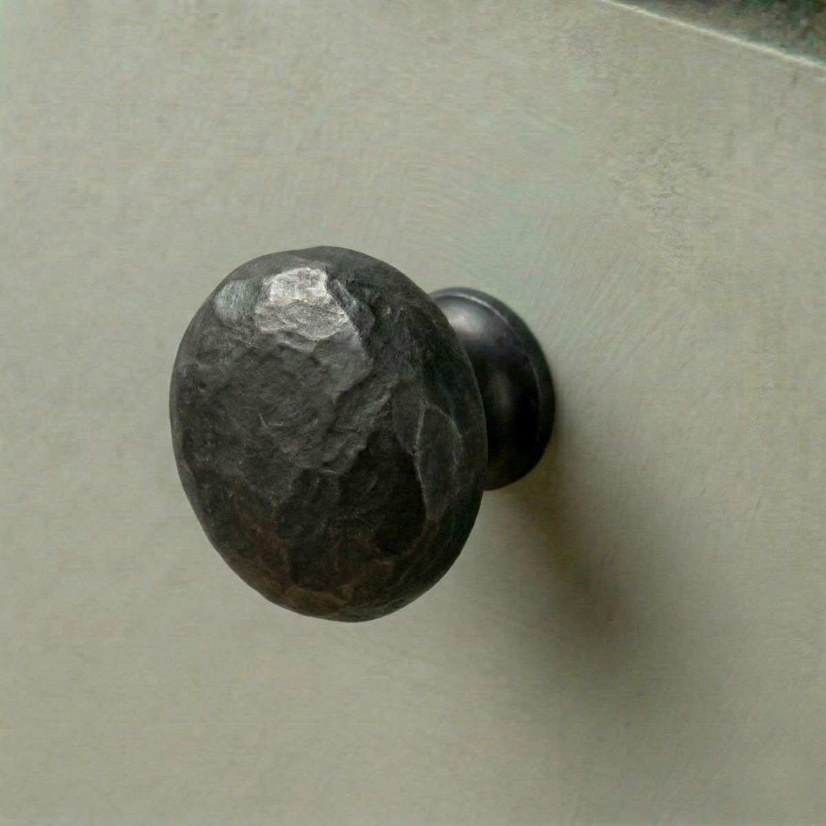 Digital Illustration of the 38mm Hammered Steel Cabinet Knob Mounted on a Sage Green Cupboard Door 