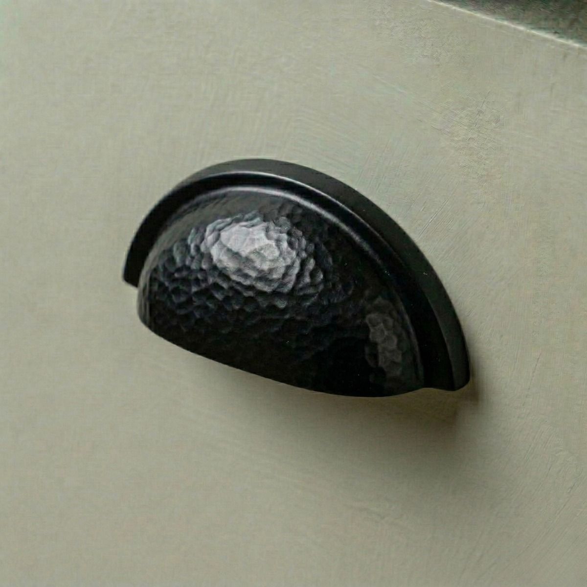 Digital Illustration of the Aged Copper Curved Drawer Pull with Hammered Handle Mounted on a Sage Green Cupboard Door