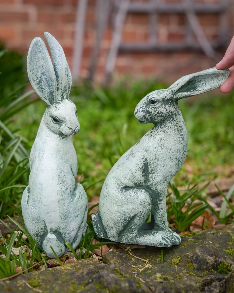 Digital illustration of Verdant Watchers Pair of Sitting Rabbit Garden Sculpture Cast Aluminium with hand in shot for scale
