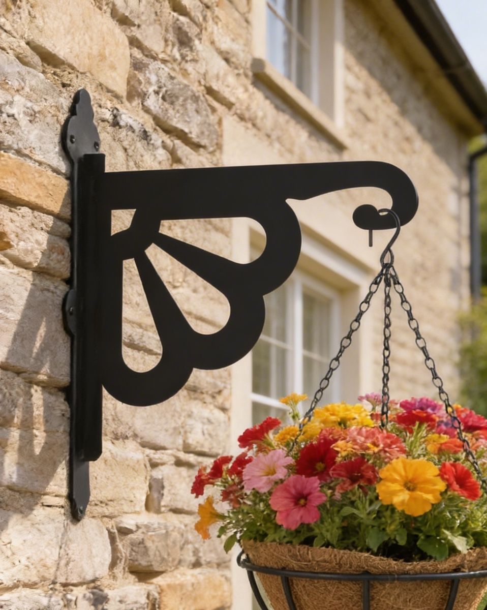 Digital representation of Clam Design Heavy Duty Iron Hanging Basket Bracket mounted on a farmhouse