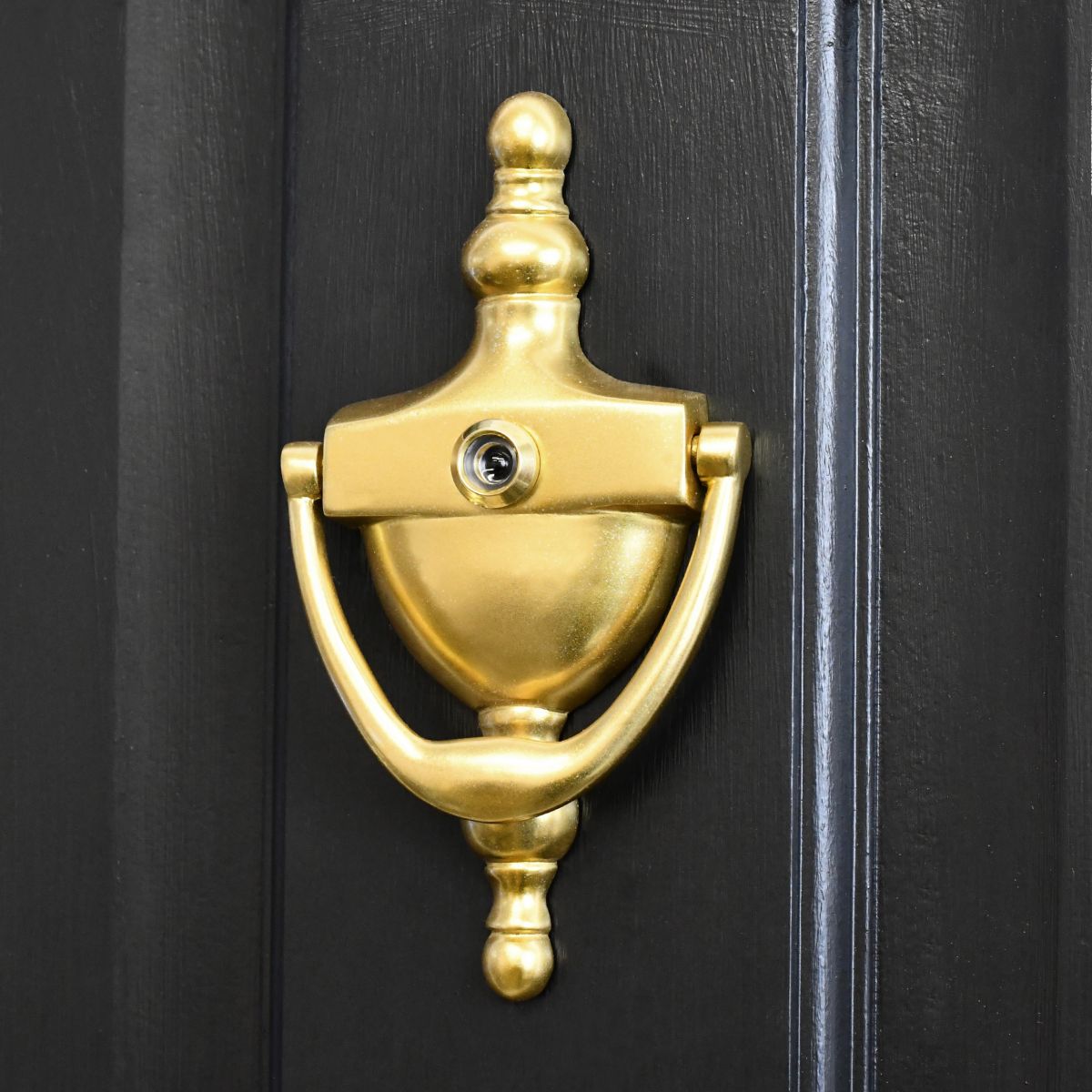 Polished Brass Urn door knocker with security viewer on black door