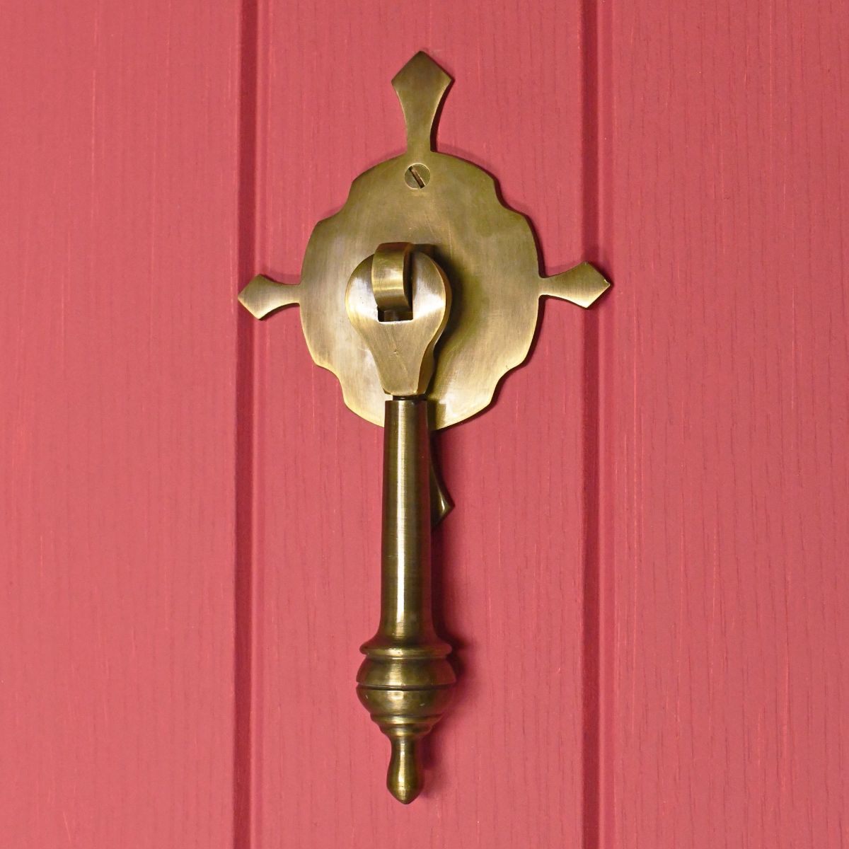unique Antique Brass Pendulum door knocker on red door