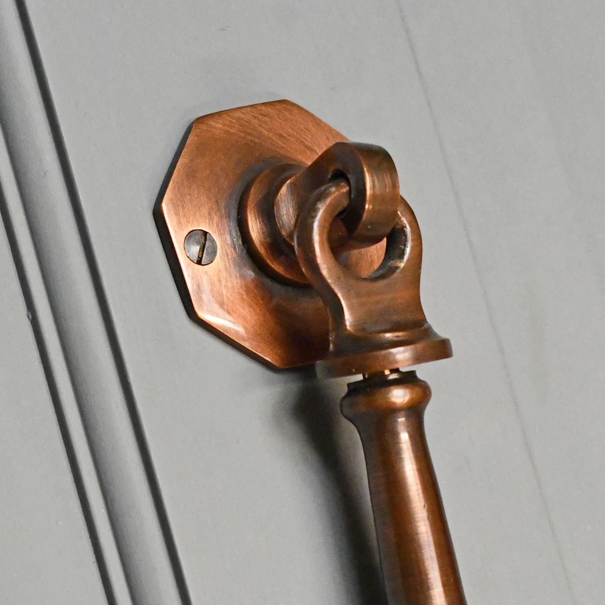 close up of mounting plate on antique copper door knocker close up of mounting plate on antique copper door knocker