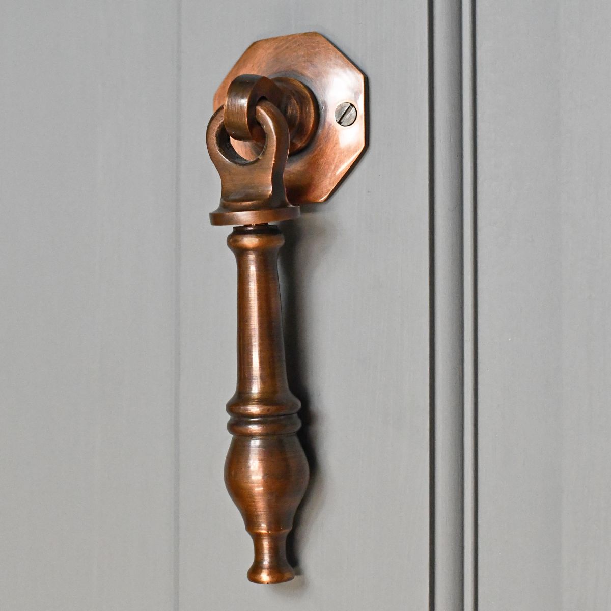 Pendulum traditional door knocker on grey door Pendulum traditional door knocker on grey door
