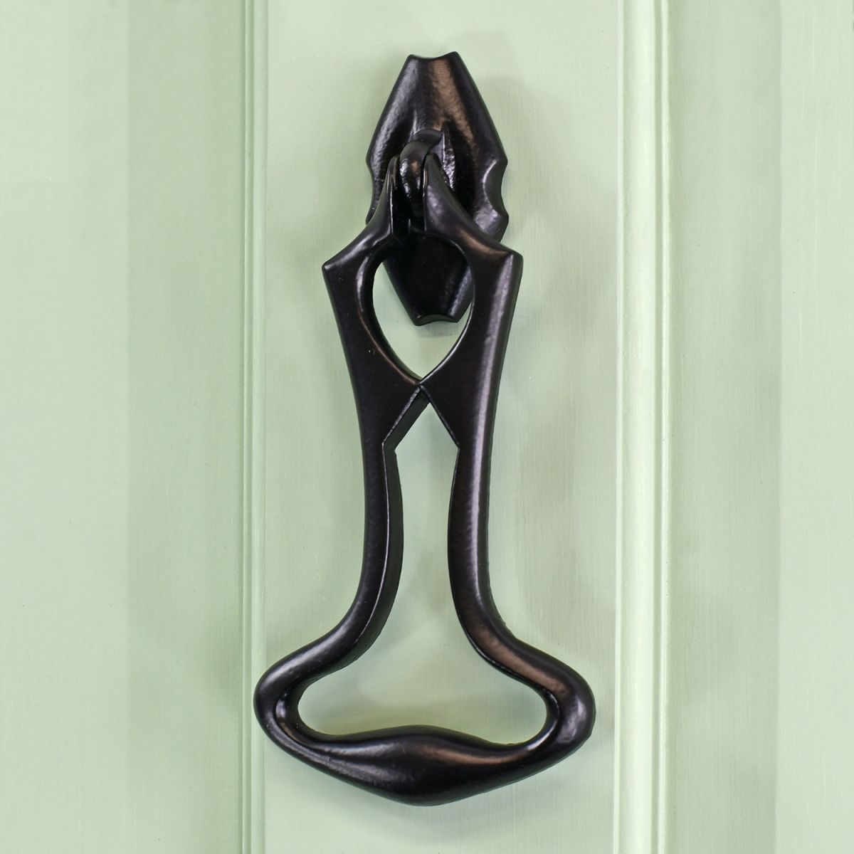 Black Iron Art Deco Door Knocker on green wood Door