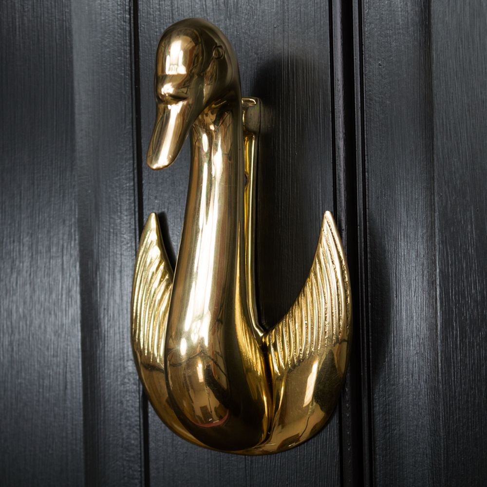Swan door knocker mounted on black door