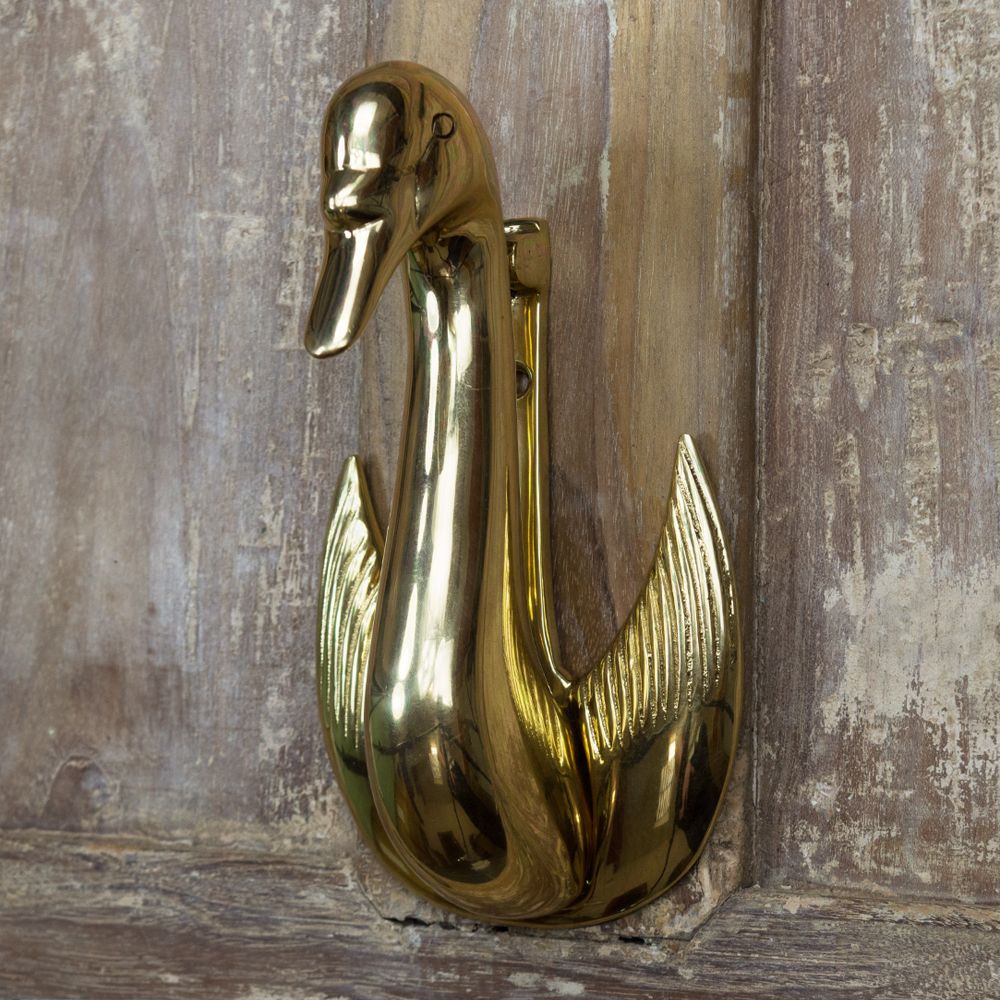Swan design door knocker mounted on Brown door