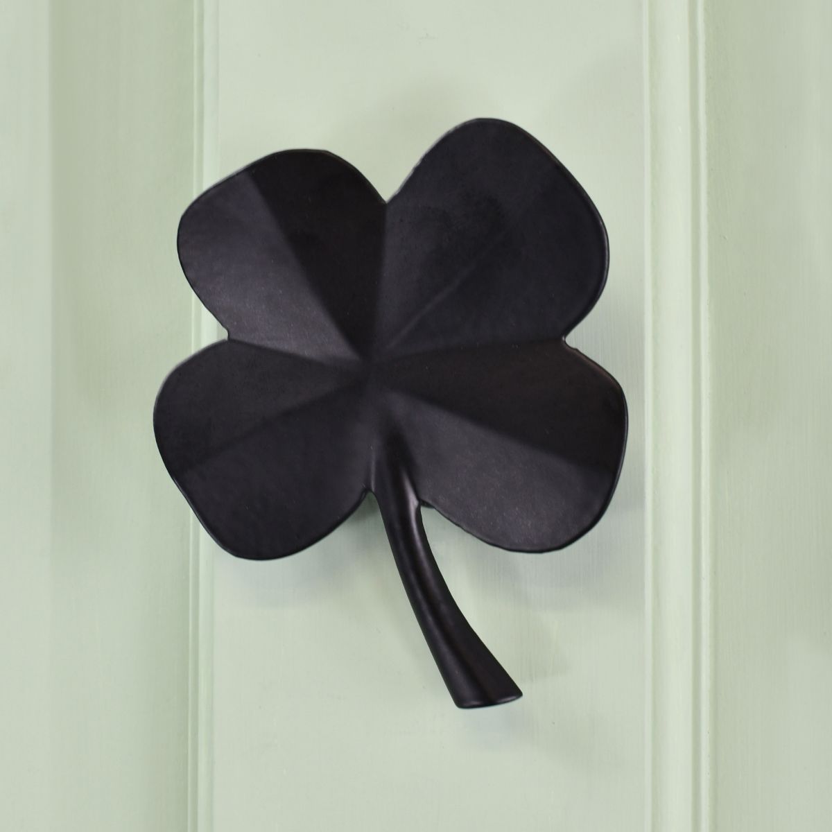 Black Four leaf clover door knocker on green door