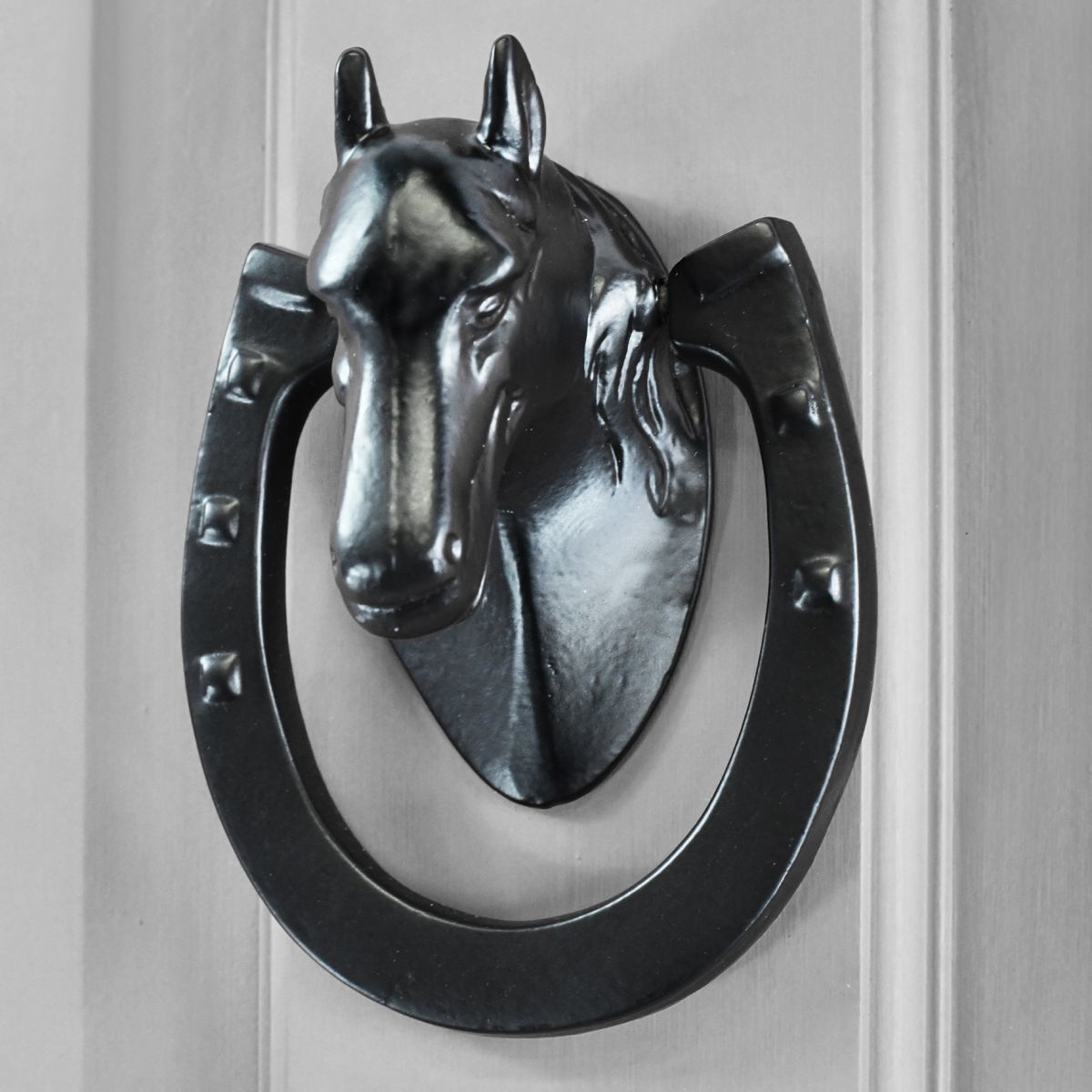 Black Equestrian door knocker on grey door Black Equestrian door knocker on grey door