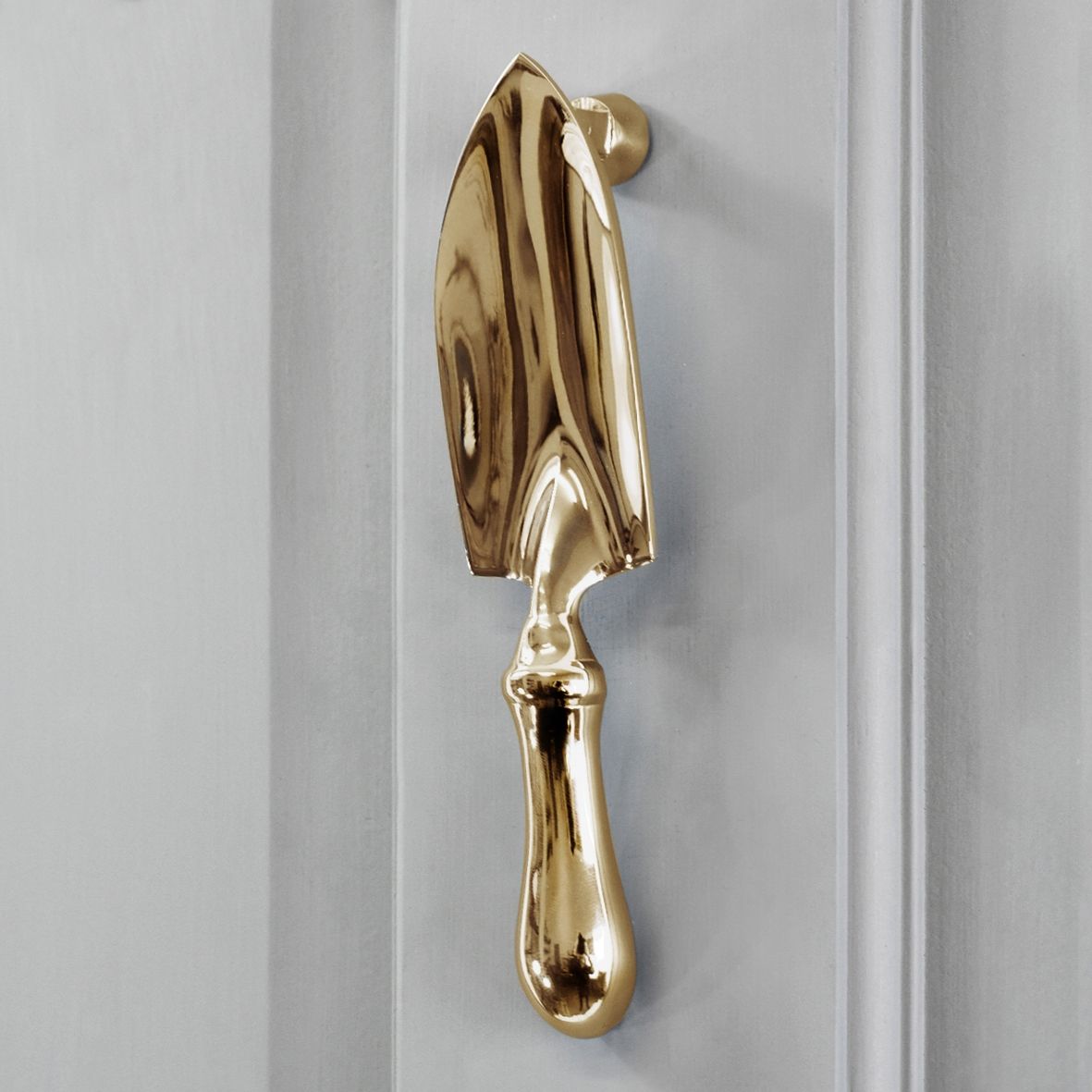 Polished brass gardening door knocker on Grey door Polished brass gardening door knocker on Grey door