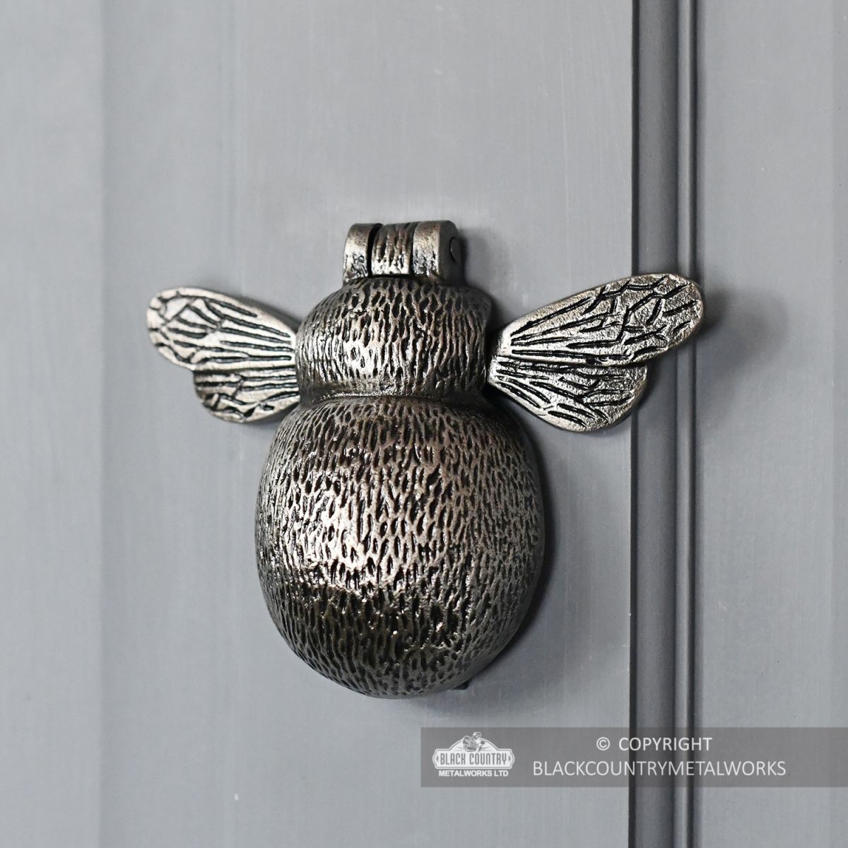 Antique Pewter Bumblebee Door Knocker on a Light Grey Door