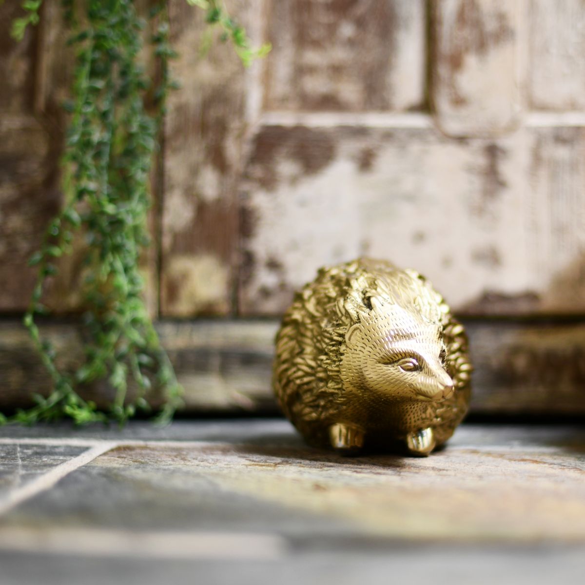 Quirky animal hedgehog door stop next to rustic door