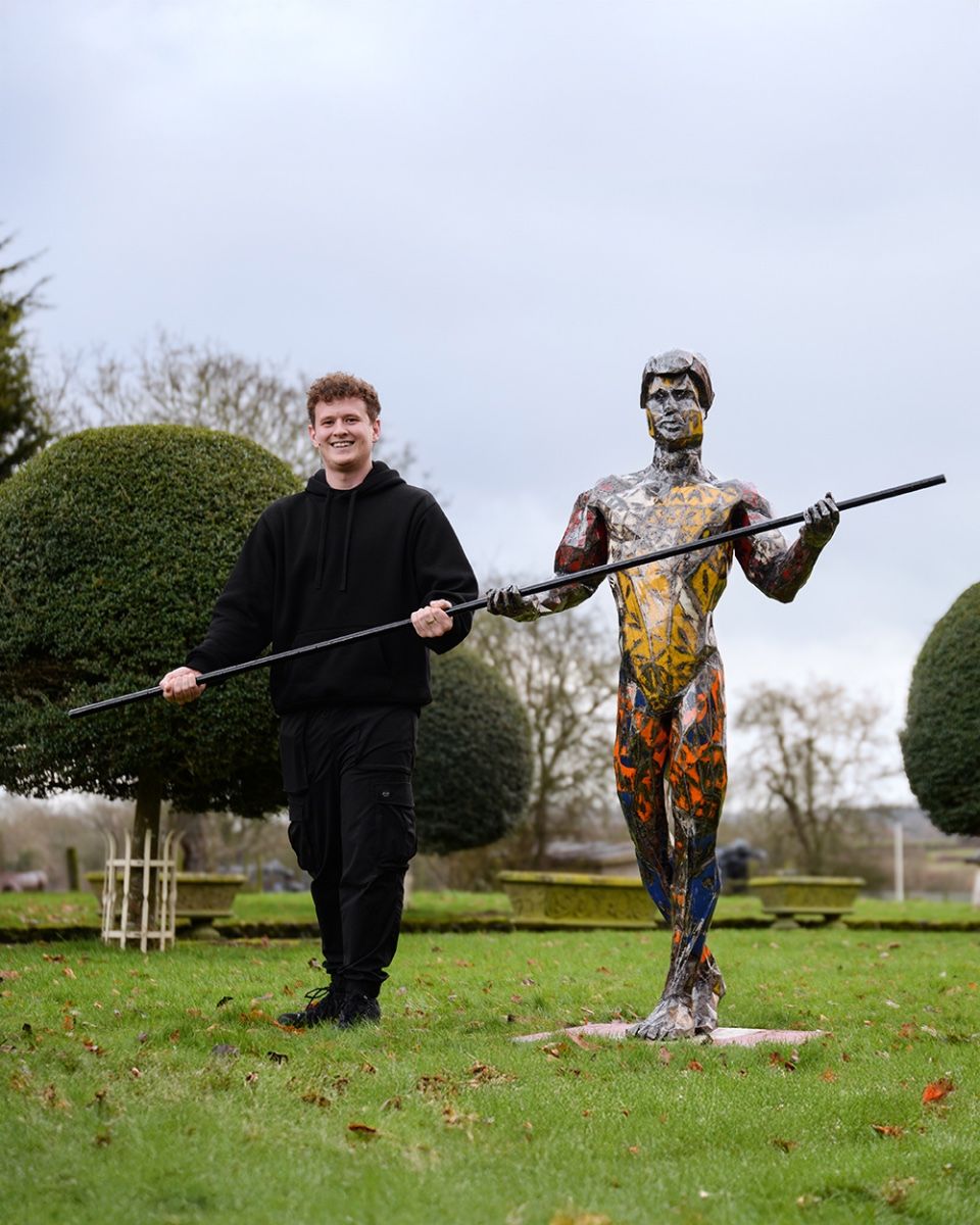 ‘Vertigo’ the Tightrope Walker Upcycled Oil Drum Garden Sculpture with man stood next to sculpture pretending to balance