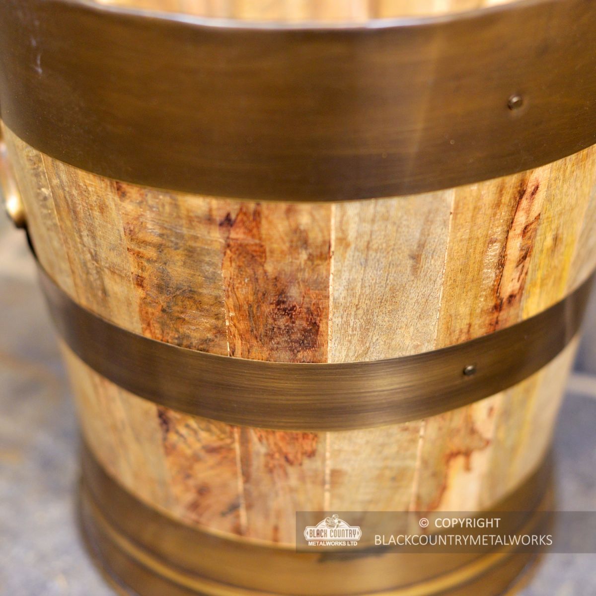 Close-up of the Bronze and Wood on the Side of the Log Basket