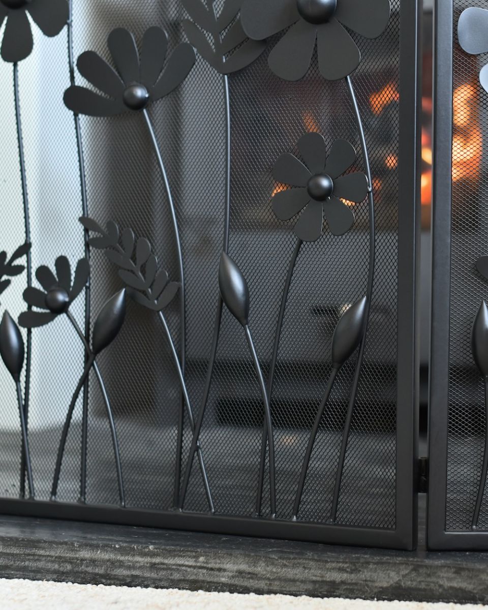 Close up of flower detail on black decorative fire screen Close up of flower detail on black decorative fire screen