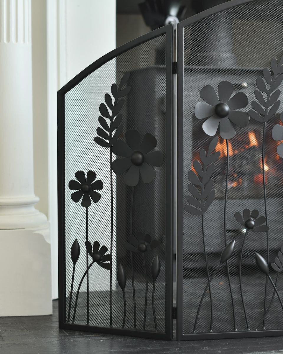 Close up of mesh and flowers detailing on triple fold ornate fire screen Close up of mesh and flowers detailing on triple fold ornate fire screen