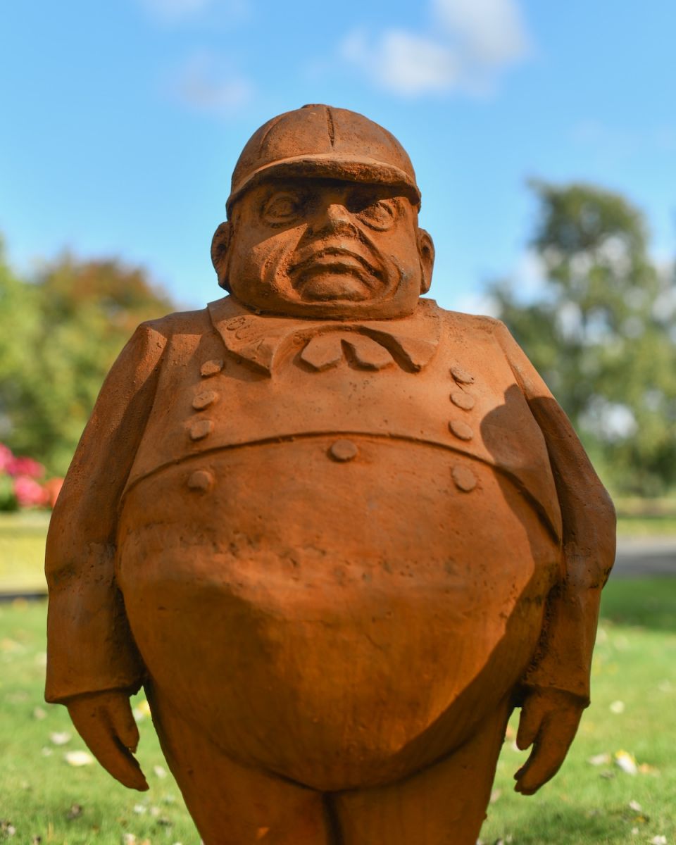 Close up of Tweedledum character garden statue Close up of Tweedledum character garden statue