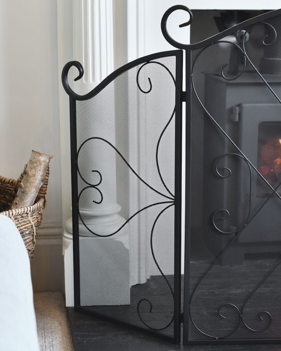 Close up of ornate detailing on decorative black fire guard Close up of ornate detailing on decorative black fire guard