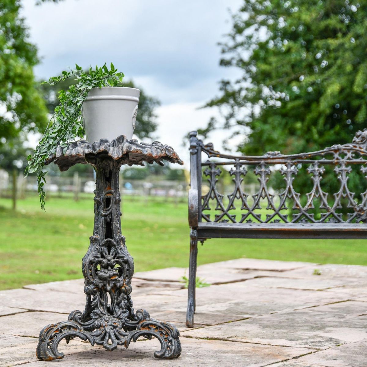 Aged Black Vintage Gothic Side Table in Garden Setting Aged Black Vintage Gothic Side Table in Garden Setting