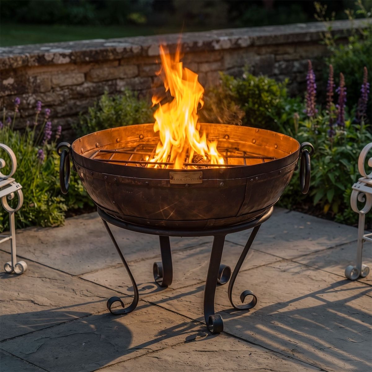 Digital Illustration of the 70cm Version of the Iron Kadai Fire Bowl Fully Lit on a Garden Patio At Night