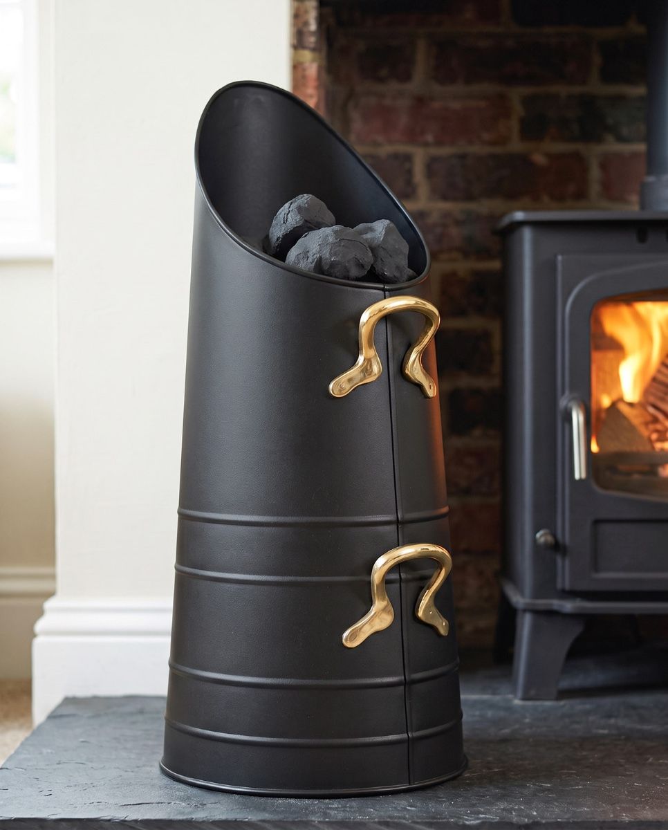 The Traditional Norfolk Coal Hod with Brass Handles Placed in a Contemporary Living Room with a Lit Log Burner Behind - Digital Illustration 