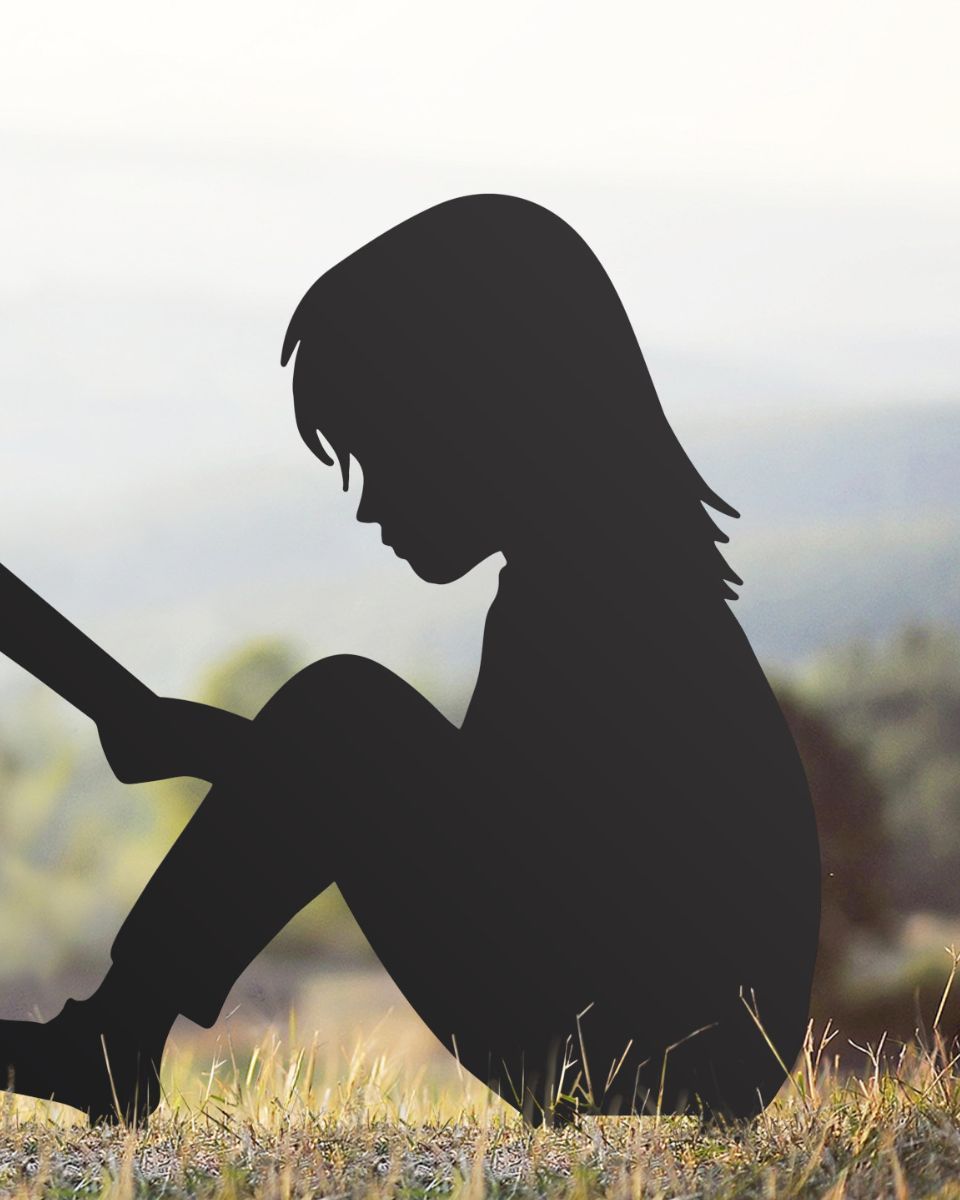 Girl Reading Steel Silhouette sitting on grass 