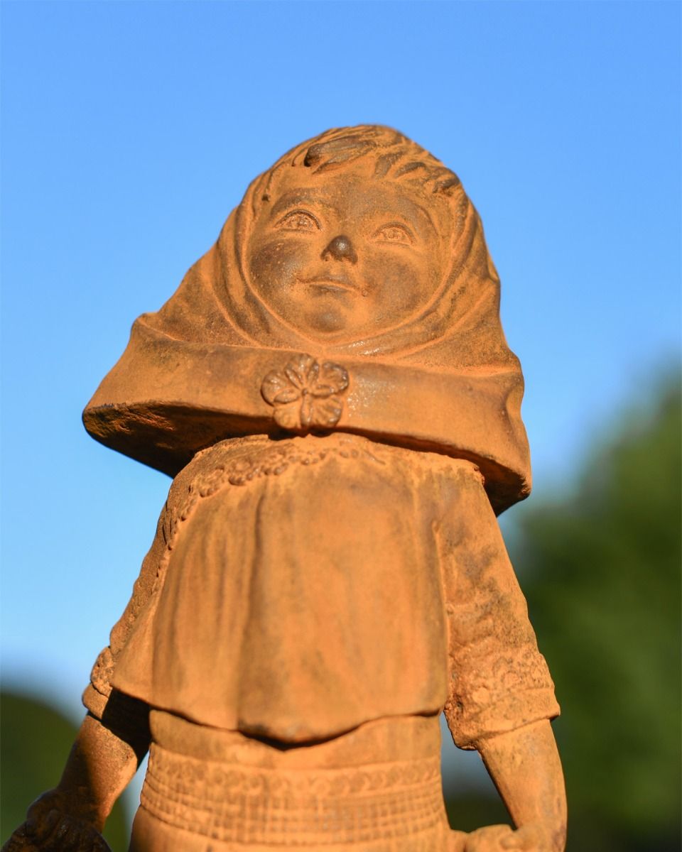 Close up of Rustic Cast Iron Girl With Basket  Close up of Rustic Cast Iron Girl With Basket
