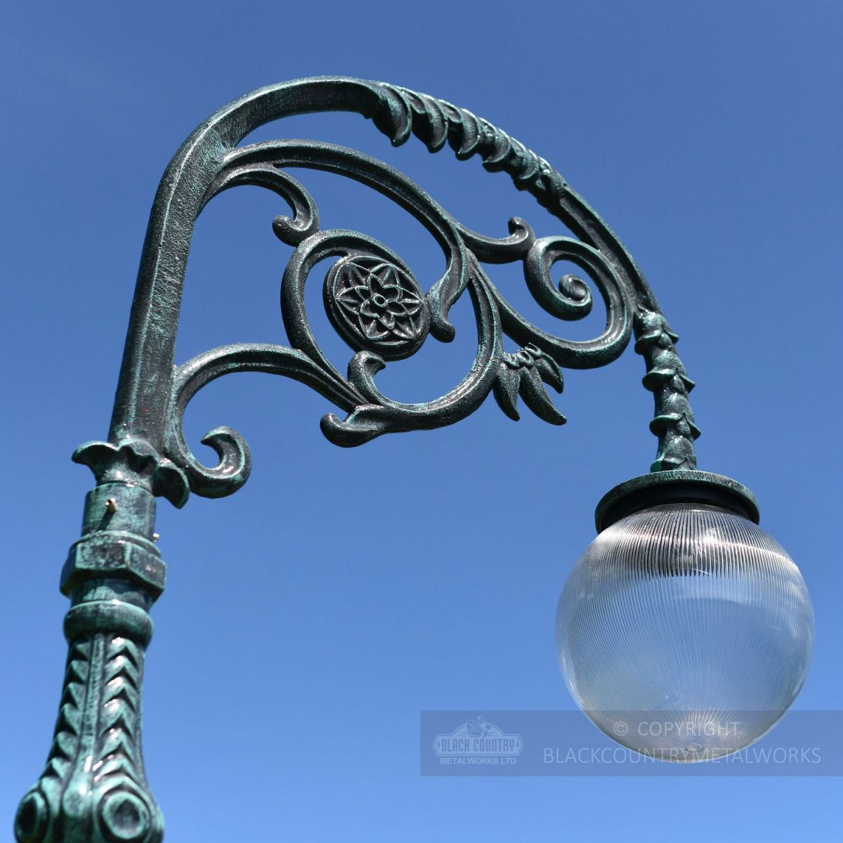Globe Luminaire on ornate scroll lamp post bracket
