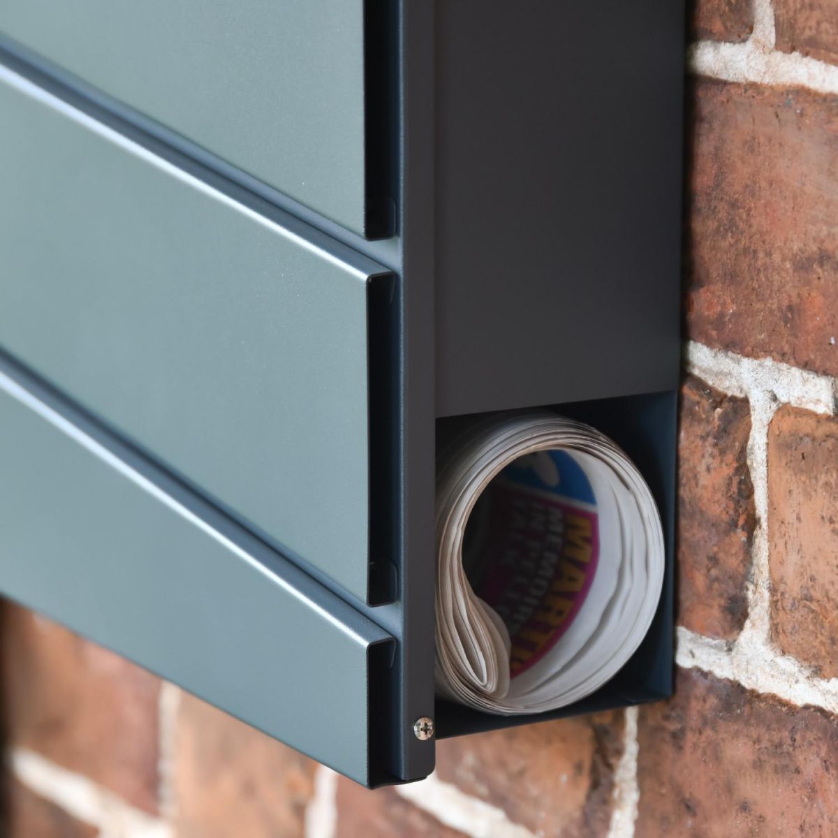 Close-Up of Newspaper Holder on Wall-Mounted Post Box Close-Up of Newspaper Holder on Wall-Mounted Post Box