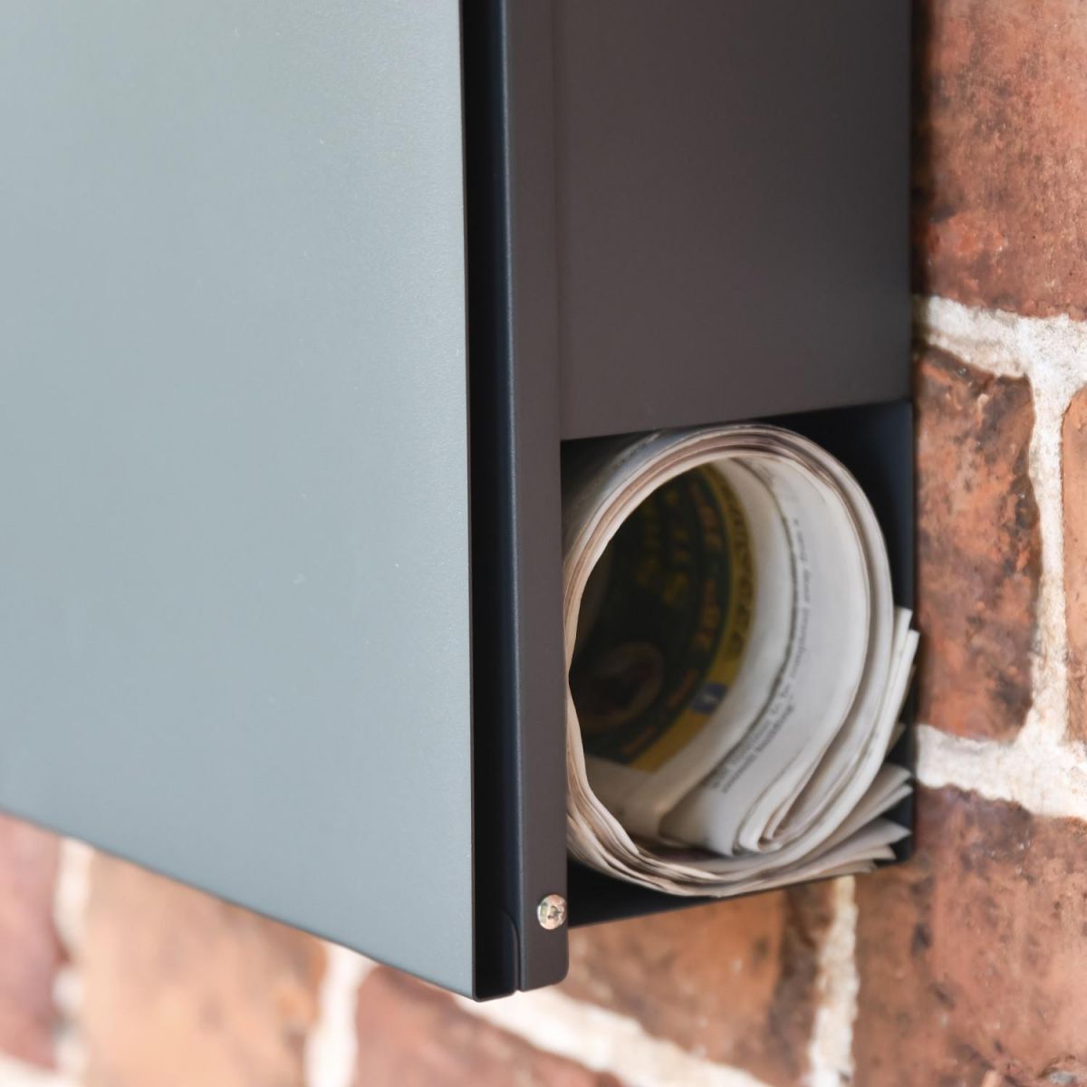 Close-Up of Newspaper Holder on Wall Mounted Post Box Close-Up of Newspaper Holder on Wall Mounted Post Box