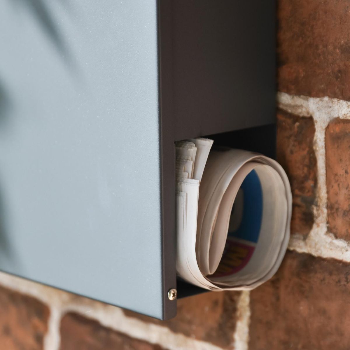 Close-Up of Newspaper Holder on Wall Mounted Post Box