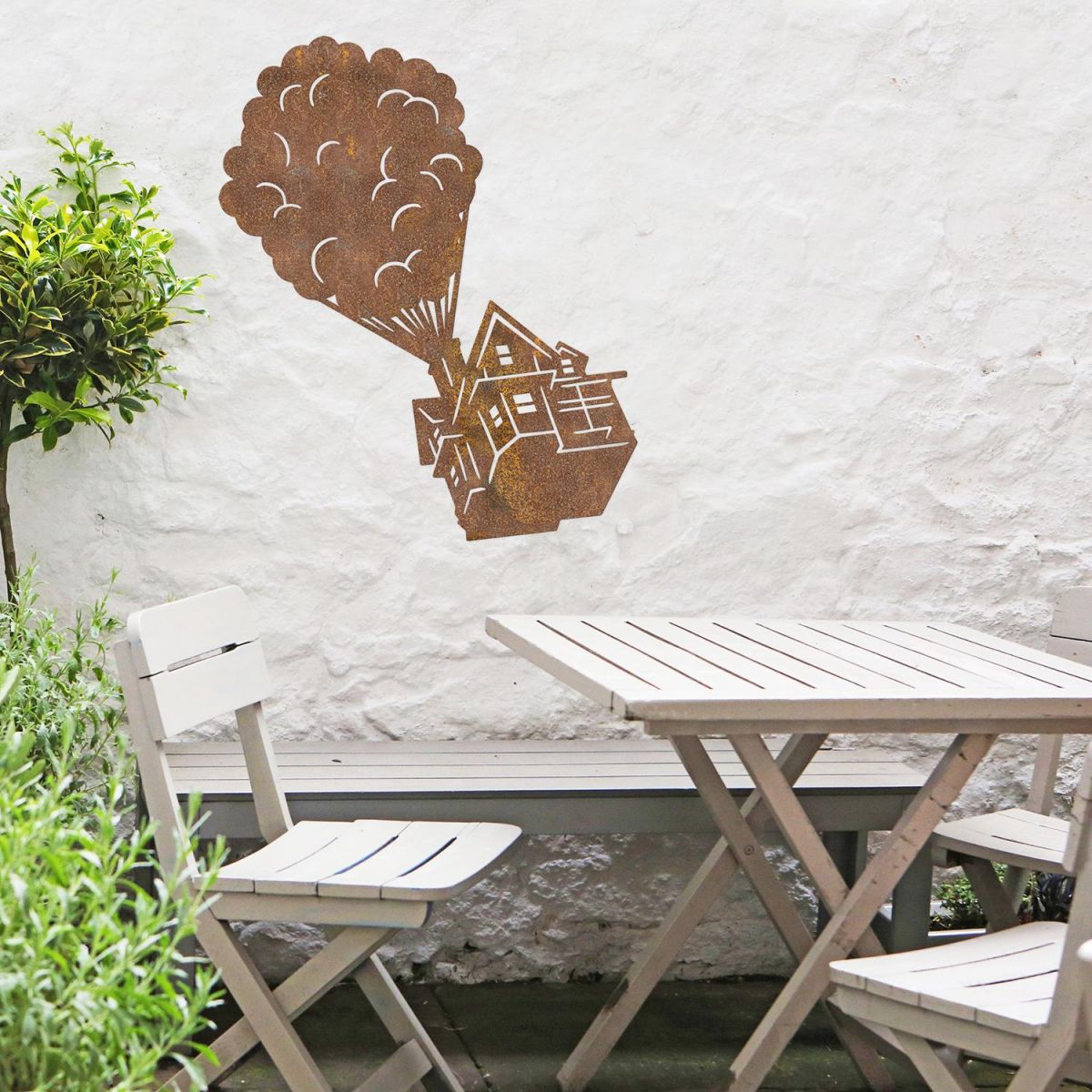 Floating House on Balloons Steel Wall Art above a Wooden Table set